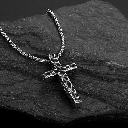 Men's vintage hammered-texture cross necklace on a grey rock