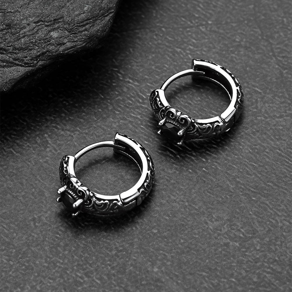 Pair of silver hoop earrings on a dark textured surface