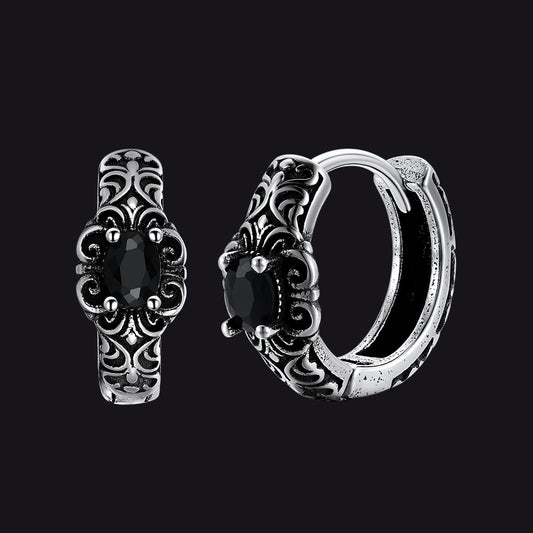 Pair of silver hoop earrings with black gemstones on a black backgroundimg