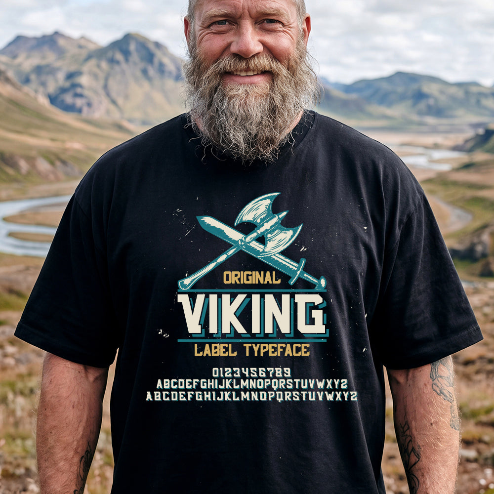 Man wearing a black t-shirt with Viking Norse Axes design in a mountainous landscape