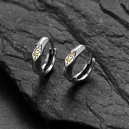 Pair of silver Wishing Stone Sun Pattern Hoop Earrings on a dark stone surface