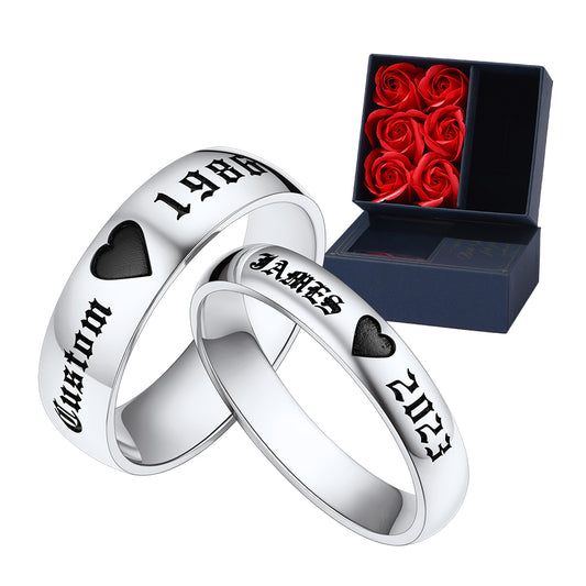 Two silver couple promise rings with engraved text next to a box of red roses.img