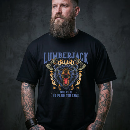 Man wearing a black t-shirt with a graphic design and text, standing against a dark background.