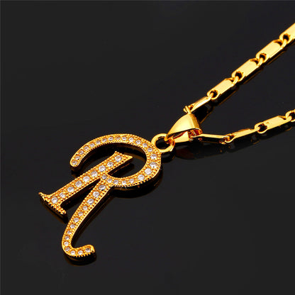 Gold necklace with a 'R' pendant on a black background