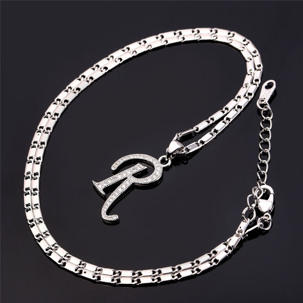 Silver bracelet with a letter 'R' charm on a black background
