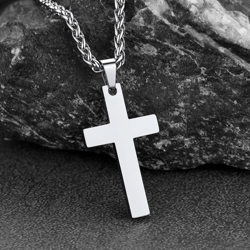 Stainless steel cross pendant necklace for men on a stone background