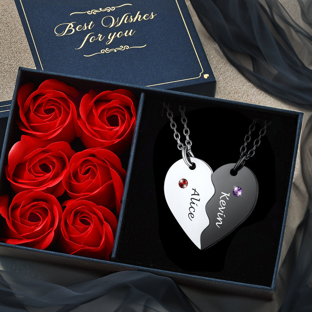Heart-shaped silver necklace with engraved names and red roses in a box with 'Best Wishes for you' card.